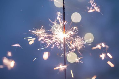 Yeni yıl arkaplanındaki havai fişeklerden yapılmış güzel kıvılcımlar, mavi arka plan, Noel havası, parıltı, tatil geçmişi.