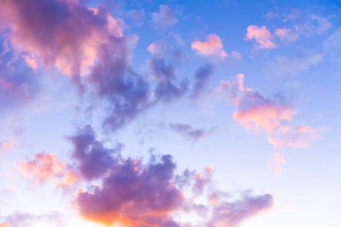 Güneş batarken, mor ve pembe renklerin canlı gölgeleri gökyüzünü kabarık bulutlarla sükunetle sürüklüyor, düşünce ve ilham için mükemmel büyülü bir atmosfer yaratıyor..