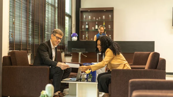 Two business workers or a couple travelers are waiting and taking facility service at an exclusive airline lounge. Travelers get refreshment at a private lobby to be ready for their trip.