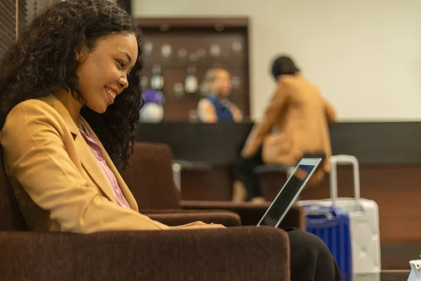 Female business traveler using airport lounge or lobby to prepare for her trip. Business woman is checking online information while waiting for her flight in a VIP room