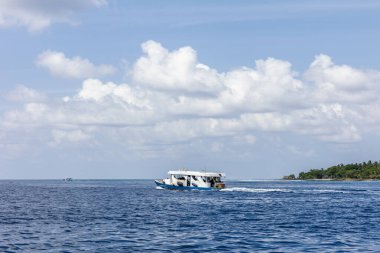 Sürat teknesi güneşli bir günde bir yerden başka bir yere, derin mavi okyanusun ortasında koşuyor.