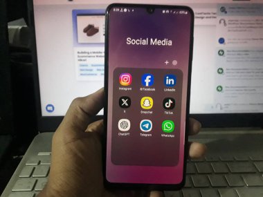 Popüler sosyal medya uygulamaları ve ekranda Chat GPT ile el ele tutuşan akıllı telefon. Bangladeş - 26 Ekim 2023