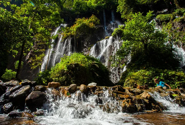 Turistler Goa Tetes şelalesinin varış noktalarının keyfini çıkarıyorlar. Tumpak Sewu kompleksindeki şelalelerden biri, birçok su akıntısının aktığı doğal bir alan..