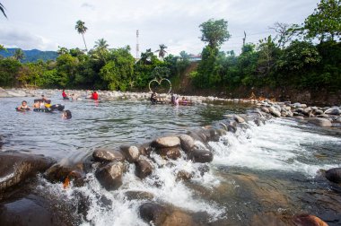 Turistler Lubuk Paraku, Bangek Nehri, Padang Şehri 'nde nehir turlarının keyfini çıkarıyorlar. Her yaştan turistler aktiftir, banyo yapar, yüzer veya balıklarla oynar..