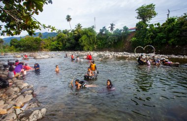 Turistler Lubuk Paraku, Bangek Nehri, Padang Şehri 'nde nehir turlarının keyfini çıkarıyorlar. Her yaştan turistler aktiftir, banyo yapar, yüzer veya balıklarla oynar..