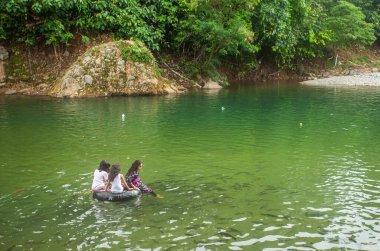 Turistler Lubuk Paraku, Bangek Nehri, Padang Şehri 'nde nehir turlarının keyfini çıkarıyorlar. Her yaştan turistler aktiftir, banyo yapar, yüzer veya balıklarla oynar..