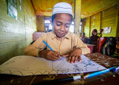 İlkokul öğrencileri Endonezya 'nın Barito Kuala kasabasında geleneksel bir sınıfta birlikte okuyorlardı..