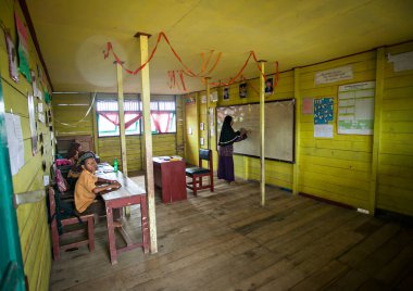 İlkokul öğrencileri Endonezya 'nın Barito Kuala kasabasında geleneksel bir sınıfta birlikte okuyorlardı..