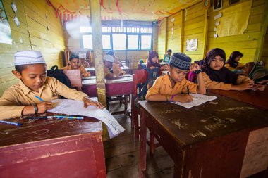 İlkokul öğrencileri Endonezya 'nın Barito Kuala kasabasında geleneksel bir sınıfta birlikte okuyorlardı..