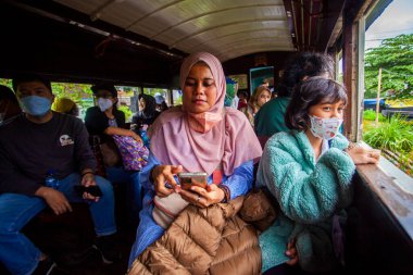 Ambarawa turist vagonundaki atmosfer. Turistler, Rawa Gölü 'nü izleyen Ambarawa tren müzesinden başlayan bir turistik tren yolculuğunun keyfini çıkarıyorlar. Semarang Regency, Endonezya 'daki Ambarawa Tren Müzesi.