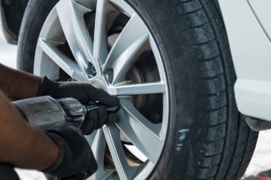Dışarıda lastik değiştiren elektrikli tornavidalı oto tamircisi. Araba servisi. Lastik kurulumu konsepti. Yüksek kalite fotoğraf