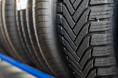 Lastik kurulumu konsepti. Kış ve yaz arabası lastikleri. Mevsimsel kış lastiği değişimi. Kar lastiği yerde yatıyor, yerleştirmeye hazır, bahar. Yüksek kalite fotoğraf