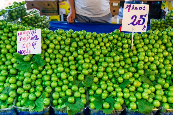 background from green plums , summer fruit green plum sold in open air market, Marketer and stall selling green plums in open air market. High quality photo
