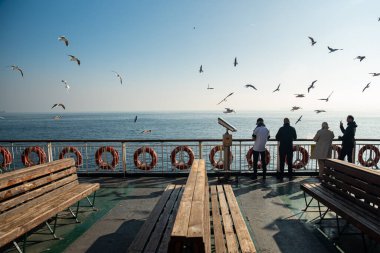 İstanbul, TURKEY 11 Kasım 2022: Yolculuk boyunca feribottan deniz manzarasını izleyen turistler, ailesiyle tatile çıkan Arap turistler. Yüksek kalite fotoğraf