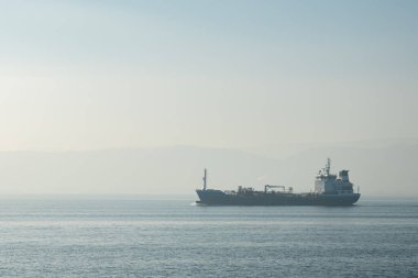Cargo Ship at Sea , Aerial view of a solo cargo ship on the move in open waters during sunrise. High quality photo
