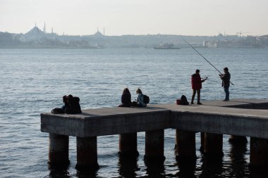  istanbul, Turkey January 3 2020 : Maidens Tower view in the background and people watching the view on the pier on the beach. High quality photo
