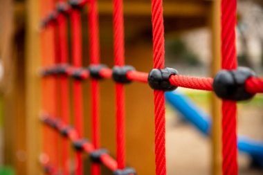climbing net in childrens playground , red rope Childrens playground in the city park. , . High quality photo