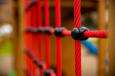 climbing net in childrens playground , red rope Childrens playground in the city park. , . High quality photo