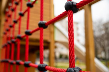 climbing net in childrens playground , red rope Childrens playground in the city park. , . High quality photo