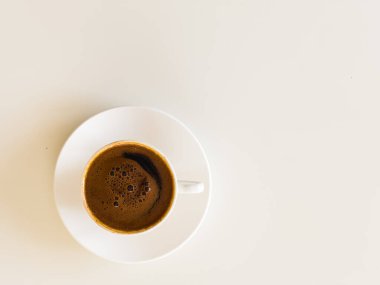 Küçük beyaz porselen bardak ve çay tabağı sıcak siyah Türk kahvesi, kahve kültürü konsepti. Beyazda izole edilmiş. Üst Manzara. Yüksek kalite fotoğraf