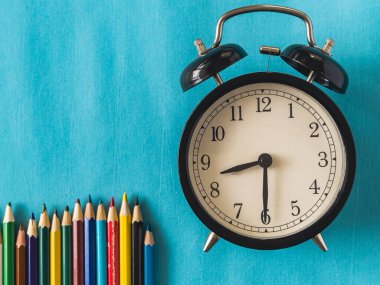 Ürün görüntüleme montajı için boşluk kopyala. Mavi arkaplandaki klasik çalar saati kalemlerle kapat. Yüksek kalite fotoğraf