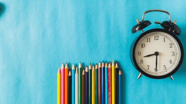 Ürün görüntüleme montajı için boşluk kopyala. Mavi arkaplandaki klasik çalar saati kalemlerle kapat. Yüksek kalite fotoğraf