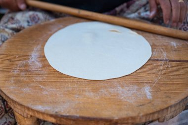 Geleneksel mini masa üzerinde yuvarlanan hamuru kadının eline takan merdane, Gözleme 'yi hazırlamak geleneksel bir Türk aperatifi. Yüksek kalite fotoğraf