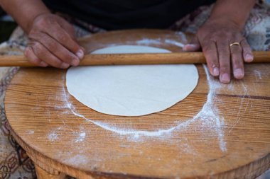 Geleneksel mini masa üzerinde yuvarlanan hamuru kadının eline takan merdane, Gözleme 'yi hazırlamak geleneksel bir Türk aperatifi. Yüksek kalite fotoğraf