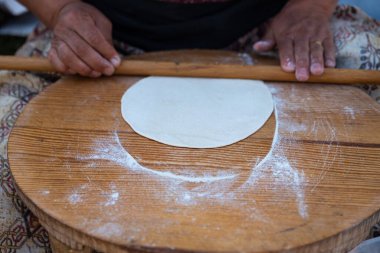 Geleneksel mini masa üzerinde yuvarlanan hamuru kadının eline takan merdane, Gözleme 'yi hazırlamak geleneksel bir Türk aperatifi. Yüksek kalite fotoğraf