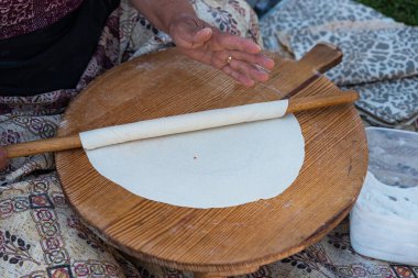 Geleneksel mini masa üzerinde yuvarlanan hamuru kadının eline takan merdane, Gözleme 'yi hazırlamak geleneksel bir Türk aperatifi. Yüksek kalite fotoğraf
