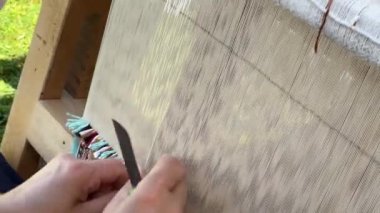 Halı dokuma tezgahında geleneksel teknikler kullanılıyor. Dokuma ve el yapımı halı üretimine yakın plan..