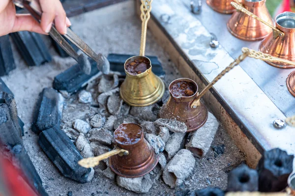 Making Turkish coffee with traditional methods , Coffee slowly cooking on heated sand. High quality photo