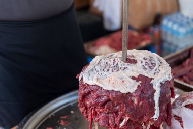 Usta Türk kebabını kırmızı etten pişirmeye hazırlıyor, pişmemiş donör kebap eti, Yunan jiroskopu bir restoranda tükürükte. Yüksek kalite fotoğraf