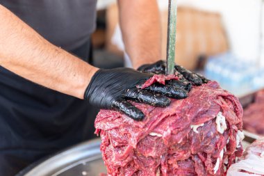 Usta Türk kebabını kırmızı etten pişirmeye hazırlıyor, pişmemiş donör kebap eti, Yunan jiroskopu bir restoranda tükürükte. Yüksek kalite fotoğraf