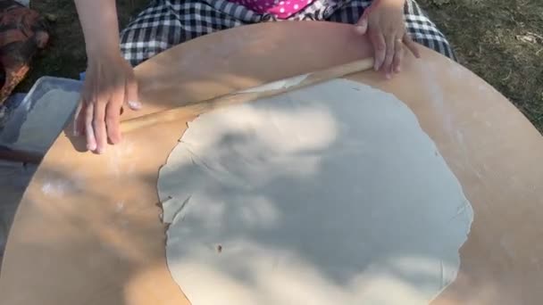 반죽을 구르는 여성은 전통적인 음식을 사용하여 반죽을 구릅니다 — 비디오