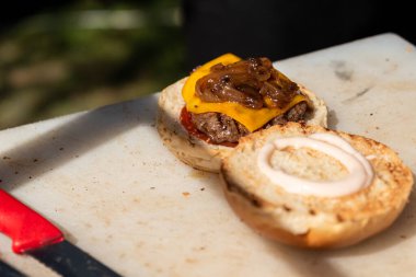 Hazır hamburger servisi, Cheeseburger tezgahta bıçaklarla servis için hazırlandı. Yüksek kalite fotoğraf