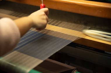 Geleneksel tekstil üretimi, tekstil sanayisi için dokuma ipliği pamuk ve ipek iplik kullanarak ve mekanik ahşap makine kullanarak örgü örerek örülüyor., . 