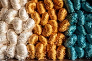 Tekstil fabrikasında dokumak için renkli ipek iplikler, pamuk rengi el yapımı doğal boyalar, eski dokuma tezgahı ve iplik ipliği.. 