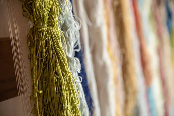 Colorful silk threads for weaving in a textile factory , Cotton color natural dyes handmade, old weaving loom and thread of yarn.