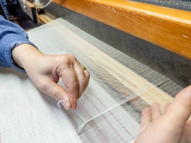 Geleneksel tekstil üretimi, tekstil sanayisi için dokuma ipliği pamuk ve ipek iplik kullanarak ve mekanik ahşap makine kullanarak örgü örerek örülüyor., . 