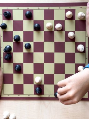 Satranç oynuyorum. Satranç oynuyorum. Çocuk satranç oynuyor ve okul ortamında bir taşın yerini değiştiriyorum.. 