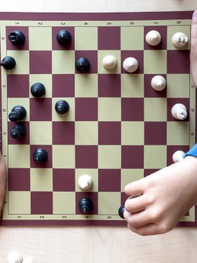 Satranç oynuyorum. Satranç oynuyorum. Çocuk satranç oynuyor ve okul ortamında bir taşın yerini değiştiriyorum.. 