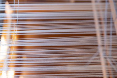 Dokuma, geleneksel el sanatları, dokuma tezgahının yakın çekimi, pamuk ve ipek iplik kullanarak esneme ve dokuma makinesini kullanarak örgü örmek.