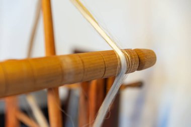 Dokuma, geleneksel el sanatları, dokuma tezgahının yakın çekimi, pamuk ve ipek iplik kullanarak esneme ve dokuma makinesini kullanarak örgü örmek.