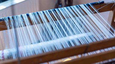 Dokuma, geleneksel el sanatları, dokuma tezgahının yakın çekimi, pamuk ve ipek iplik kullanarak esneme ve dokuma makinesini kullanarak örgü örmek.