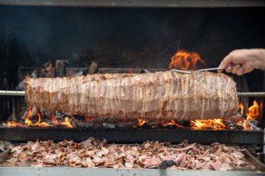 Wood fired Turkish Cag Kebab Doner. Cag kebab, a traditional Turkish cuisine dish made from lamb meat cooked on wood fire.  clipart