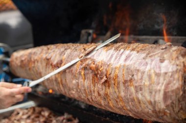 Wood fired Turkish Cag Kebab Doner. Cag kebab, a traditional Turkish cuisine dish made from lamb meat cooked on wood fire.  clipart