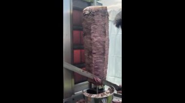 Şef geleneksel Türk yemeği Doner Kebap 'ını keser. Bir aşçı et keser, shawarma, jiroskop, döner kebap yapmak için. Şişte et pişirmek. Yüksek kalite 4k görüntü