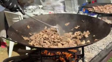 Şef ahşap ateşin üzerinde tavada et yemeği pişiriyor. Geleneksel Türk mutfağı. Yüksek kalite 4k görüntü