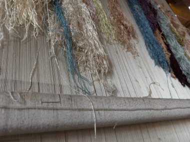 Geleneksel el dokuma tezgahı, dokuma tezgahında geleneksel teknikleri kullanarak halı dokuma. Dokuma ve el yapımı halı üretimine yakın plan.. 